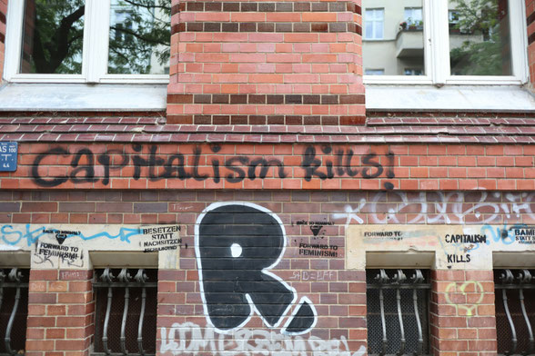 Brick wall with Capitalism Kills spray painted on the bricks