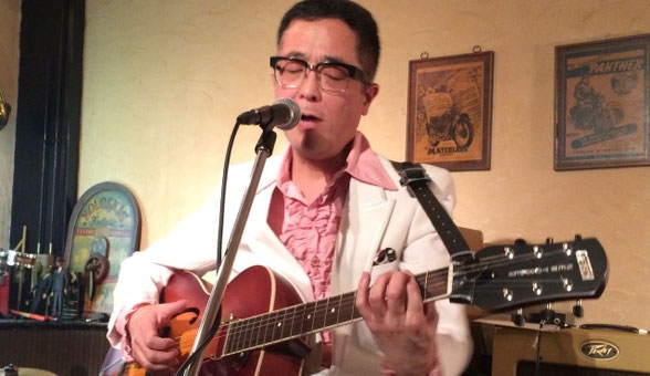 チャーリー坂本が横浜市にあるSam's Barで弾き語り演奏している場面