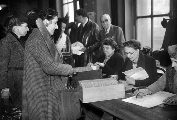 ARCHIVES) Photo de femmes votant lors du référendum du 21 octobre 1945. Le Oui est majoritaire aux deux questions, abandon de la constitution de 1875 et maintien du gouvernement de Gaulle tant que siègera la Constituante. Les communistes sortent grands va