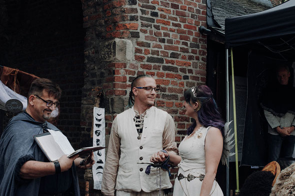 Brautpaar bei der Handfasting Zeremonie mit Trauredner in mittelalterlicher Gewandung