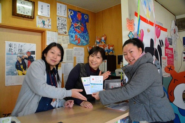 気仙沼市観光案内所の方と阿部さん。持っているのは底上げYouthが作成した観光リーフレットです。