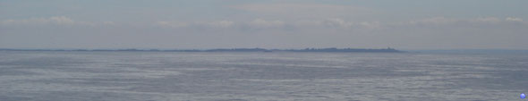 La grande île de Chausey (avec le phare à droite) et les côtes manchotes en arrière plan (© lebateaublog 2012)