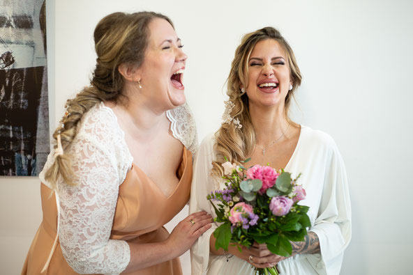 zwei lachende Frauen mit Braut-Make-Up