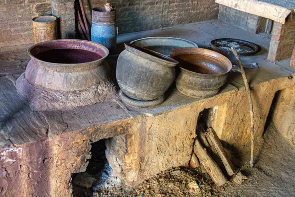 Dans les cuves chauffées, la garance réduite en poudre se mêle à l’eau. La chaleur en révèle le rouge profond, prêt à teindre le coton.