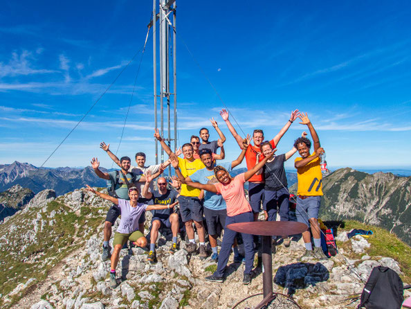 Myriam von Puls der Freiheit mit multikultureller Wandergruppe beim Integrationsprojekt Wanderglück auf einem Berggipfel in den Alpen