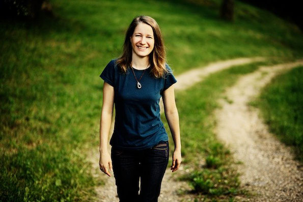 Portrait von Irene Arbeithuber, die auf einem Feldweg auf den Betrachter zugeht
