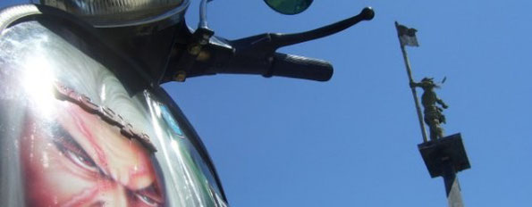 an airbrushed vespa in front of the harbour monument in Singaraja