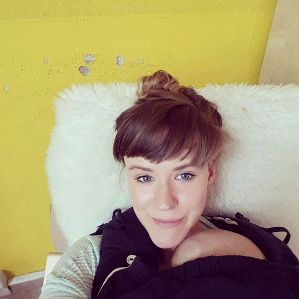 Neu-Mama in Familienzentrum in Berlin-Friedrichshain mit Baby in der Trage.