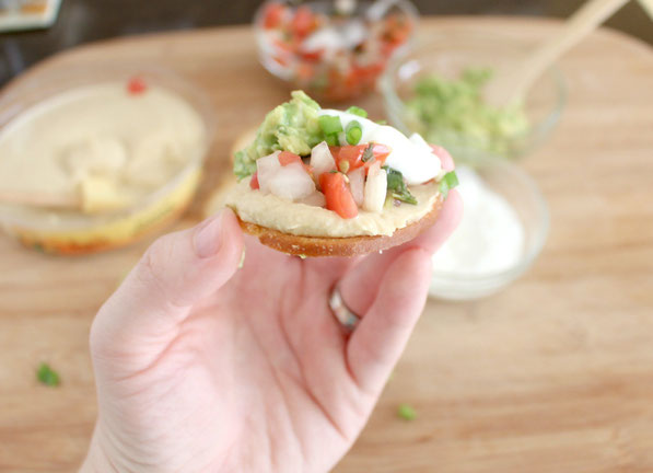 This is an easy recipe that's perfect for tailgating season!  A few simple store-bought items come together in minutes to make these Southwestern hummus bites.  Everyone will love this tasty, healthy snack!