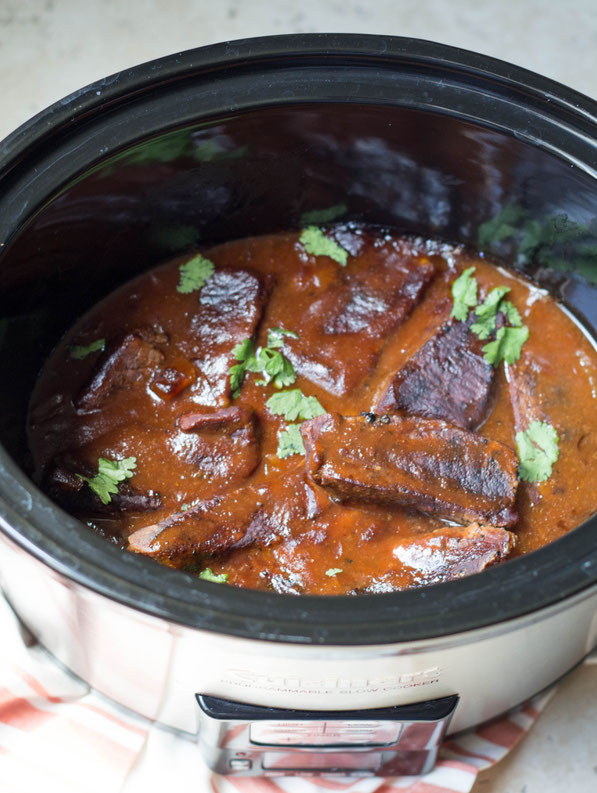 Indoor BBQ?  Yep!  These slow cooker BBQ beef ribs are super easy, and you can feed a crowd without doing much work at all! It's a great slow cooker recipe for the summer months. 