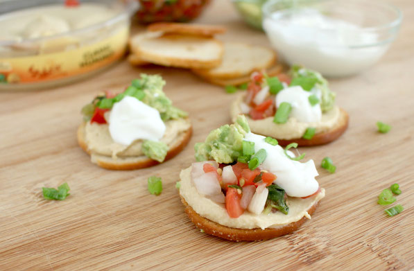 Quick hummus snack bites are the perfect semi-homemade healthy appetizer!  Store-bought hummus, avocado, pico de gallo, and Greek yogurt come together for this easy snack that people can assemble themselves at a party!