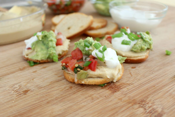 This is an easy recipe that's perfect for tailgating season!  A few simple store-bought items come together in minutes to make these Southwestern hummus bites.  Everyone will love this tasty, healthy snack!