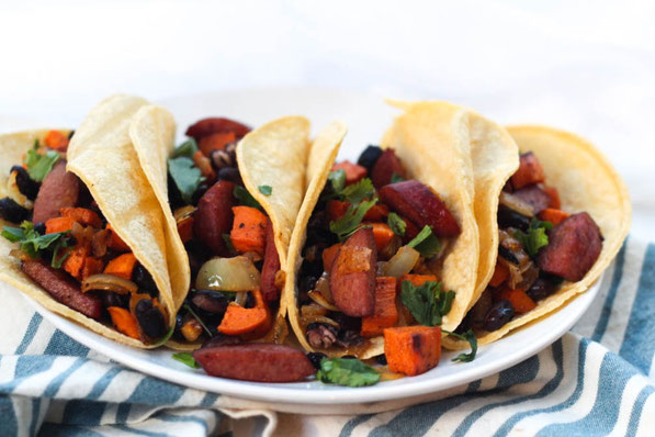 Sausage, sweet potato, onions, and black beans roast together  beautifully on a baking sheet to create the base of these delicious  (and gluten free) one-pan tacos for two!  