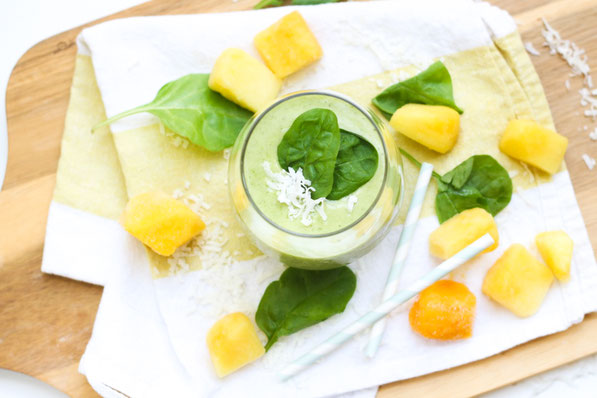 This tropical healthy green smoothie recipe made with spinach, pineapple, coconut, and mango is the perfect light summer breakfast!