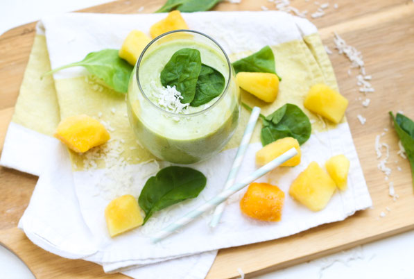 This tropical healthy green smoothie recipe made with spinach, pineapple, coconut, and mango is the perfect light summer breakfast!