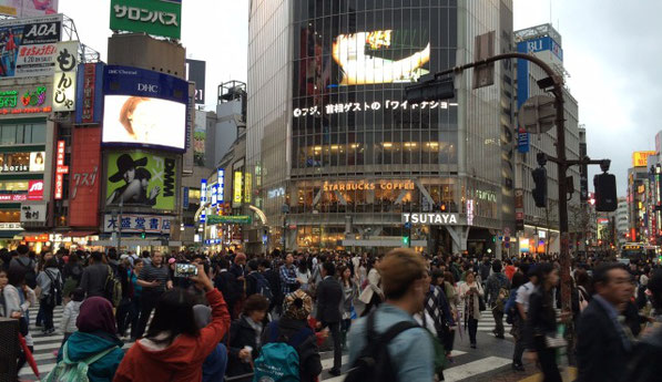 渋谷のスクランブル交差点で沢山の人が横断歩道を渡っている風景