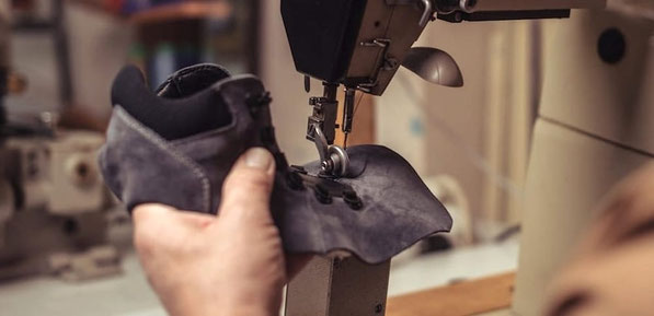 Manufaktur Mitarbeiter näht Schaft aus Leder für Barfußschuhe