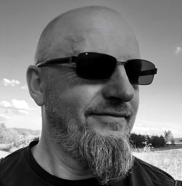 Porträt Frank Demann mit Sonnenbrille und einem Lächeln im Gesicht 