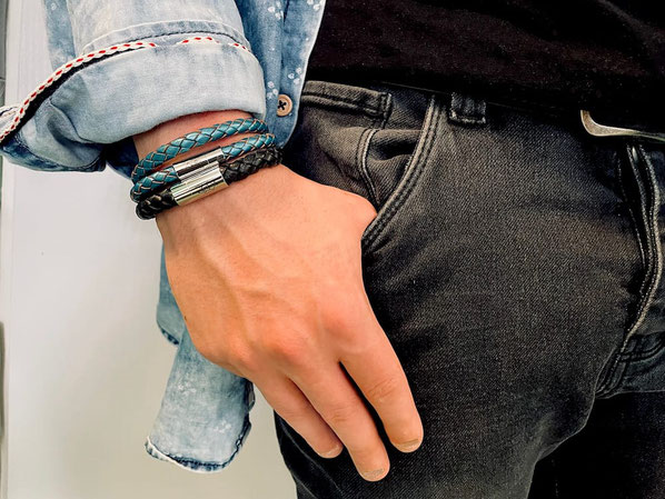 Männliches Handgelenk mit zwei Lederarmbändern in Schwarz und in Stahl mit Magnetverschluss 