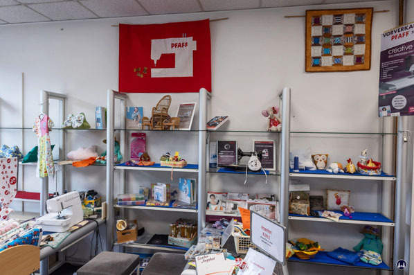 Die ursprünglich bis zum Räumungsverkauf mit den verschiedenen Nähmaschinenmodelreihen der Fa. Pfaff bestückten Regale, die sich vom Schaufenster (links) bis zur Stickgarnwand im hinteren Teil des Ladens hinzogen. 