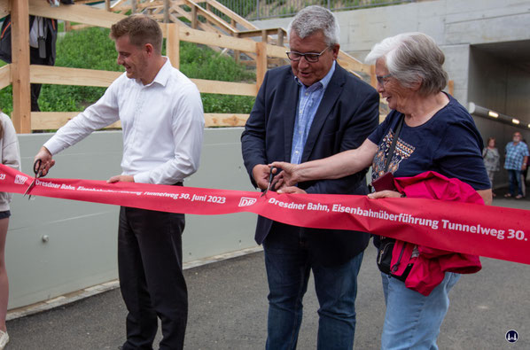 Nun geht es zur Tat, das "Rote Band" wird durchschnitten. Von links, Bahn-Projektleiter Marcus Reuner, Bürgermeister Michael Schwuchow und Ortsvorsteherin Hannelore Pappschick.