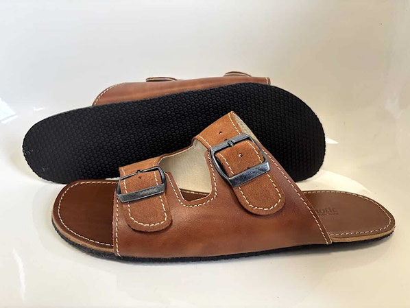 Pantolette Modell Luftikus 1 von Senmotic. Aus pflanzlich gegerbten braunem Leder mit zwei Riemen und Metallschnallen. Die 3mm Kautschuk Sohle ist Schwarz.