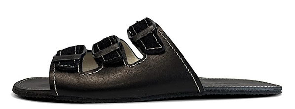 Pantolette aus schwarzem pflanzlich gegerbten Leder mit Nähten in Weiß. Mit drei verstellbaren Riemen mit Schnallen aus Metall. 