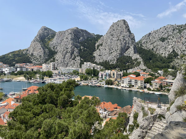 Eine steile Küstenlandschaft mit dramatischen Felsen rahmt Omiš ein 