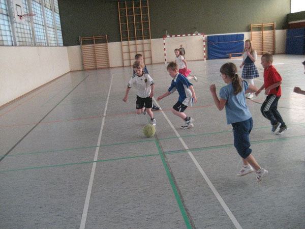 Immer der grünen Filzkugel hinterher: Die Schülerinnen und Schüler kicken den Ball durch die Halle