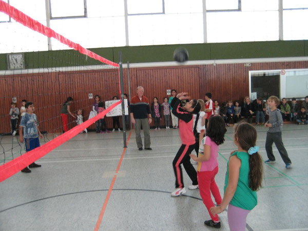 Sportomann betreut die Kinder beim Volleyball