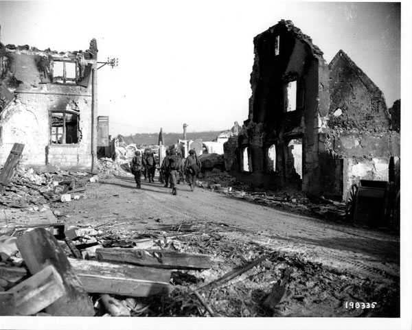 Men of L Company, 15th Infantry march through Bennwihr, December 27, 1944 (Photo courtesy National Archives)