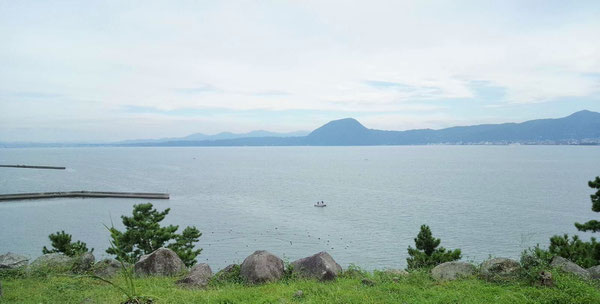 日出城天守台から、別府湾を挟んで望む高崎山（中央の小高い山）です。