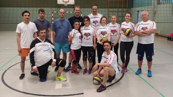 Die Freizeitvolleyballer lächeln in die Kamera