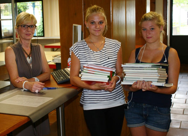 Frau Ochsenreither (verantwortlich für die Organisation der Schulbuchausleihe bei der Stadt Wörth) und Julia Emeljanow (10d) und Melissa Benz (10d), die gerade ihre nachbestellten Bücher in Empfang genommen haben