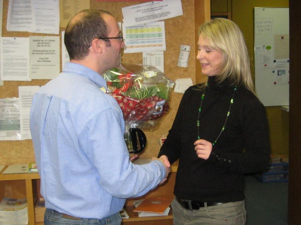 Herr Geeck überreicht Frau Gauly zum Abschied einen Blumenstrauß