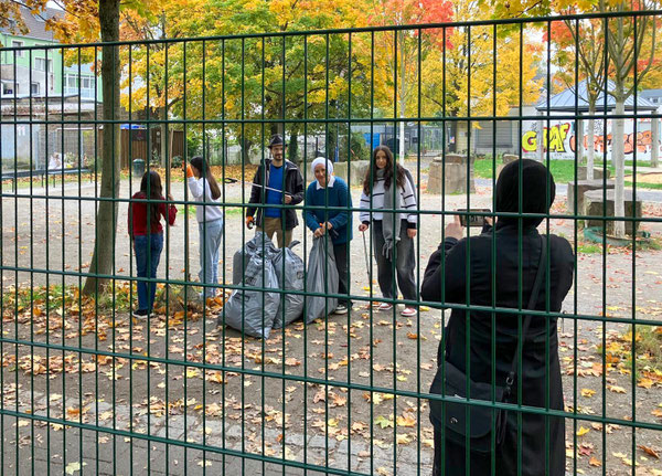Gruppenbild mit Handy: Die Hallo Nachbar Truppe mit gefüllten Müllsäcken der AWB
