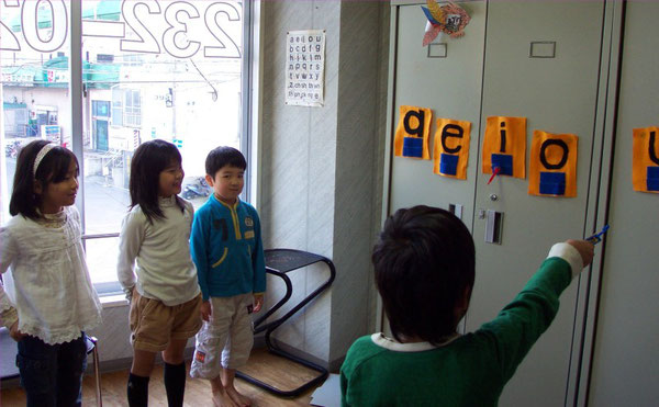 LOFT kids practicing a phonics game: shooting the vowels and saying their proper sounds (N. American phonics)