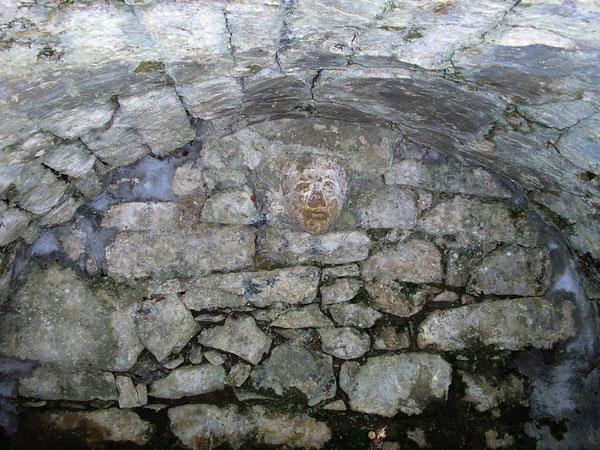 Sous la voute de la Fontaine des Cagots, un masque de pierre marque le rappel des vieux rites qui avaient cours dans le quartier...