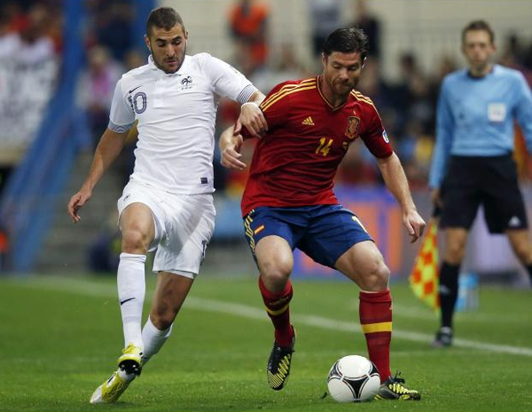 Xabi Alonso pelea por un balón con su compañero en el Real Madrid Karim Benzema.