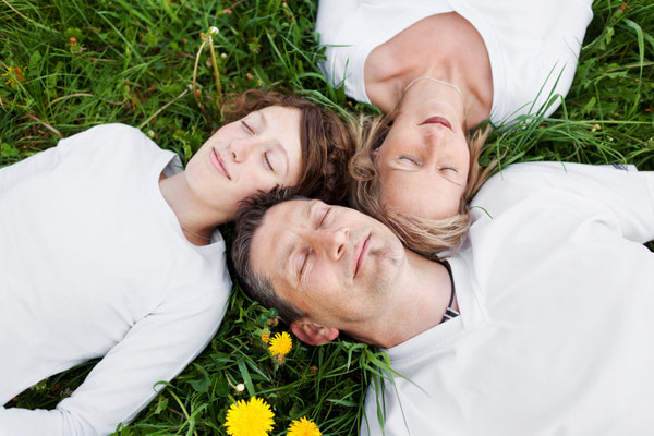 meditierende Familie liegt im Gras, auf dem Rücken liegen, träumen, Frieden in der Familie, entspannte Menschen, Vertrauen, Liebe, Frühling, Egofrei Sein
