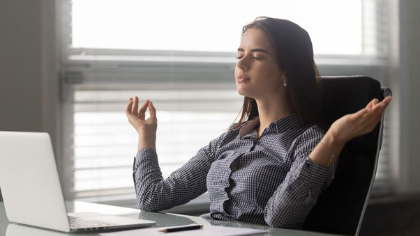 Frau meditiert am Arbeitsplatz – Verbindung von Bewusstsein, Klarheit und moderner Führung