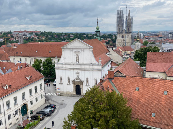 Die weiße St.Katahrina-Kirche - dahinter die zwei Türme der Kathedrale von Zagreb, ebenfalls in Baugerüsten