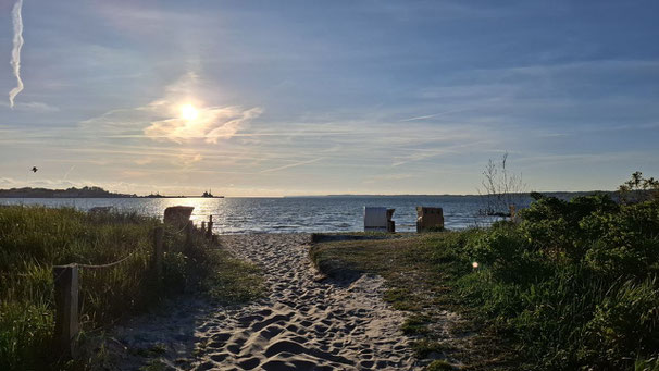 Blick über den Strand aufs Meer bei blauem Himmel