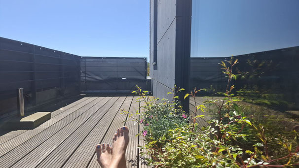 Auf einem Balkon mit Blumen und blauem Himmel