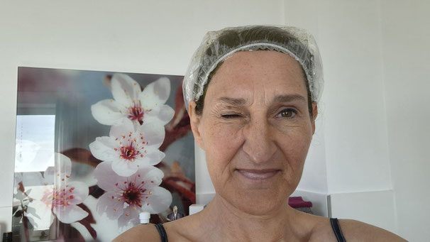 Frau mit Haube auf dem Kopf - zwinkert mit dem Auge in die Kamera