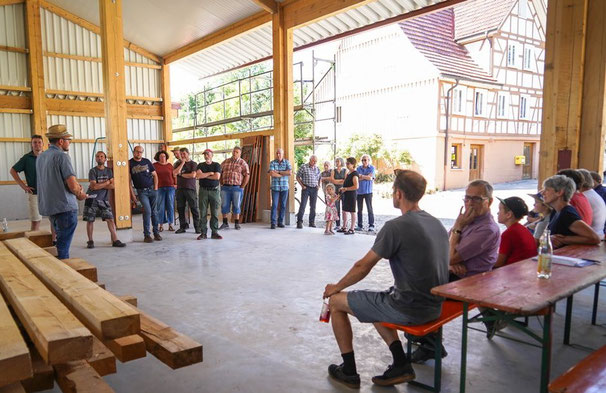 Andreas Döz stellt einer interessierten Teilnehmer(innen)gruppe sein Hallen-Neubau-Projekt vor.