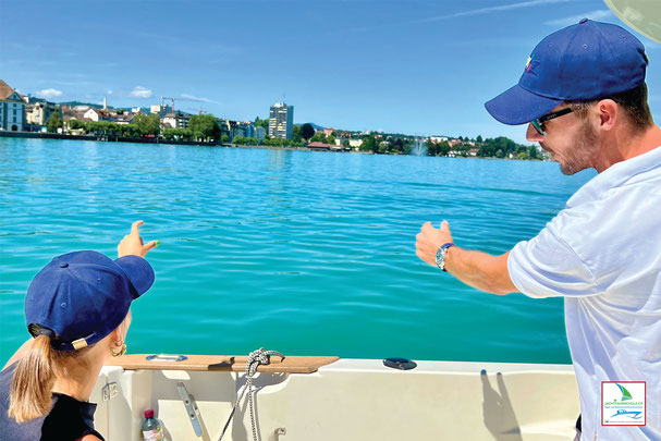 Einweisung in unseren Jachtcharter am Bodensee – HOZ Instruktor und Kundin tragen die typische HOZ Kappe