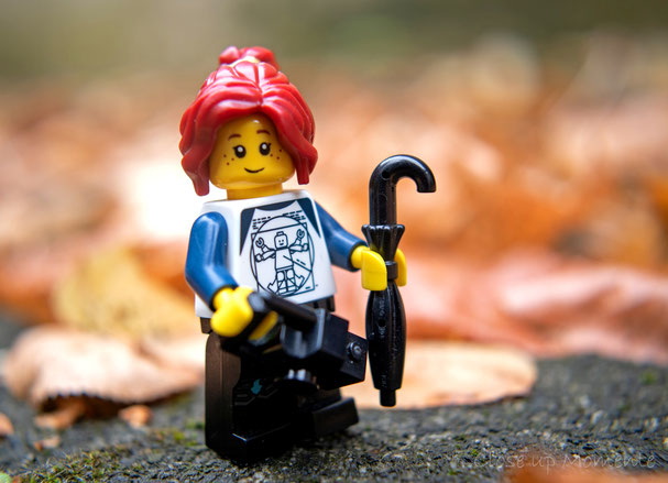 Legofigur mit Regenschirm, Herbstlaub