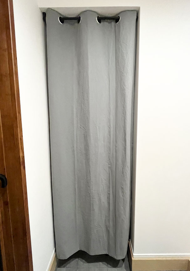 土間スペースに取り付けられた帆布のハトメカーテン。ブラックのハトメがアクセントになり、シンプルながら引き締まった印象。