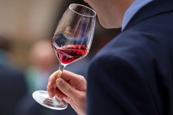 Una persona degusta un bicchiere di Pinot Nero durante le Giornate del Pinot Nero in Alto Adige, concentrandosi sul colore e sugli aromi nel bicchiere